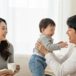 거실에서 행복하게 아이와 시간을 보내는 한국인 부부의 모습, 육아휴직으로 늘어난 가족의 유대감을 상징