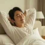 따뜻한 아침 햇살을 받으며 상쾌하게 잠에서 깨어 기지개를 켜는 한국인 여성.